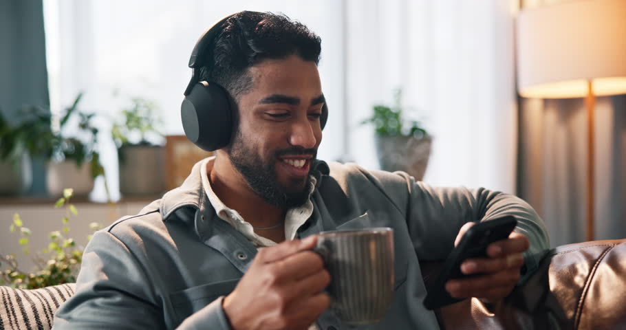 Coffee, music and phone with man on sofa for streaming, songs playlist or relax. Audio subscription, calm podcast and connection with person with beverage in home for album, headphones and listening