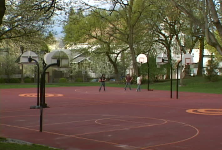 Group of men play basketball at park as sun comes out. Series in gallery.