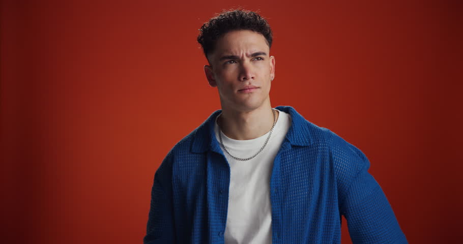 Thinking, man and confused with question in studio for doubt, uncertain and solution to memory loss. Puzzled, person and scratching head on red background for wondering, decision and problem solving