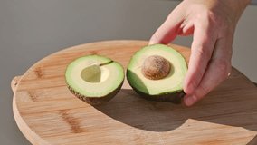 chef cuts fresh green ripe avocado on cutting board to prepare a healthy meal. outdoor cooking, food closeup - Powered by Shutterstock - Get 15% off with code: PIKWIZARD15