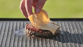 cook put melted cheese slice on freshly grilled hot burger patty meat on grill pan surface, food closeup, outdoor cooking - Powered by Shutterstock - Get 15% off with code: PIKWIZARD15