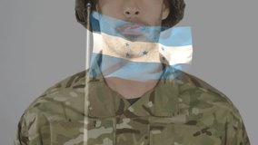 Military soldier lifting hand into salute upon waving flag overlay, honoring Honduran pride. Military, professionalism, discipline, patriotism, uniform, stoic, determination - Powered by Shutterstock - Get 15% off with code: PIKWIZARD15