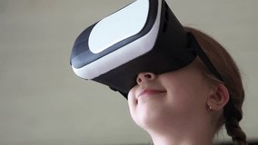 A child wearing glasses looks at the amazing future of the modern world against a neutral background. The educational process through VR glasses. virtual reality simulator. 3D gadget technology. - Powered by Shutterstock - Get 15% off with code: PIKWIZARD15