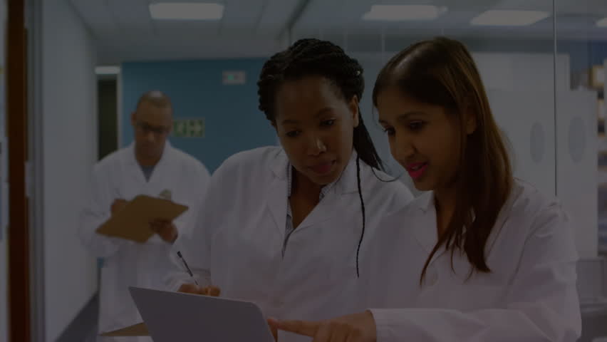 Lab scientists powering on laptop and causing binary overlay streaming while colleague noting data. Research, innovation, technology, collaboration, analytics, futuristic, professional - Powered by Shutterstock - Get 15% off with code: PIKWIZARD15