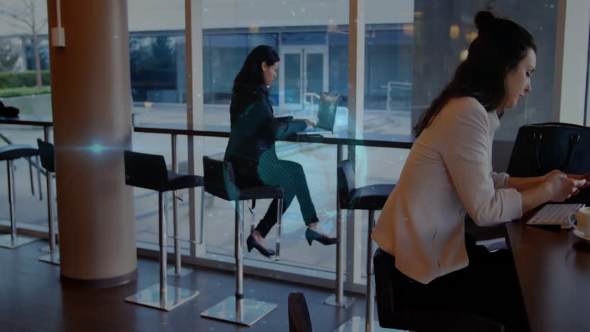 Left woman opening laptop activating hologram in technology demo while right user scrolling phone. Futuristic, collaboration, innovation, digital, workplace, modern, professional