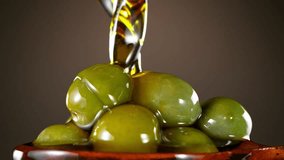 Super Slow Motion of Green Olives in Wooden Spoon with Pouring Oil . Filmed on High Speed Cinematic Camera at 1000 FPS - Powered by Shutterstock - Get 15% off with code: PIKWIZARD15