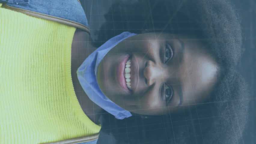 Animation of covid 19 cells and statistics over smiling african american woman in face mask. global covid 19 pandemic concept digitally generated video. - Powered by Shutterstock - Get 15% off with code: PIKWIZARD15