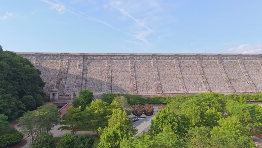 Aerial rising shot of kensico dam in New York with beautiful lake and green landscape in summer. Sunny day in July. Wide shot.