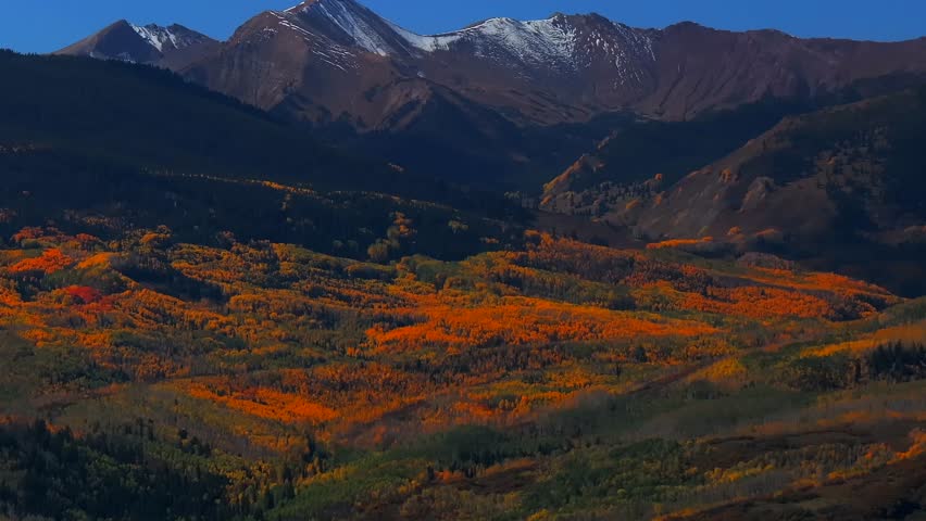 Fall Autumn sunny blue sky morning Capitol Peak Mount Snowmass aerial drone Colorado vibrant yellow orange Aspen White River National Forest snow dusting Rocky mountain peaks parallax circle right