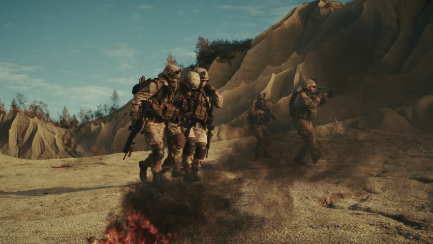 Soldiers in Desert Combat, Firing Weapons Amidst Explosions and Smoke. They Advance Strategically. Professional Military Warfare, Squad on a Hostage Saving Mission. Slow Motion