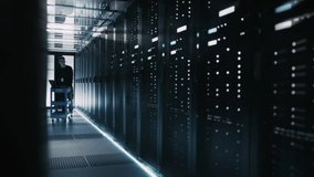IT Technician Uses a Laptop on a Rolling Cart While Inspecting Server Racks in Data Center, Network Hardware and Equipment, System Reliability Cyber Security of Artificial Intelligence Work - Powered by Shutterstock - Get 15% off with code: PIKWIZARD15