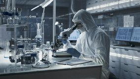 Scientist In A Full Protective Suit Works in Sterile Lab, Examining Biological Samples with Microscope. Modern Researchon Biomedical Analysis and Healthcare Innovation and Pharmaceutical Development - Powered by Shutterstock - Get 15% off with code: PIKWIZARD15