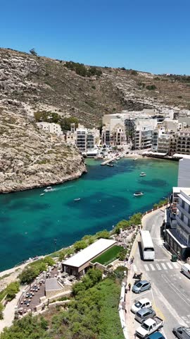 A vertical drone view of the stunning blue waters and rocky coastline of Gozo island, Malta by the Mediterranean sea