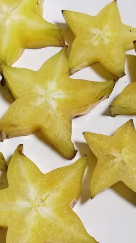 Fresh starfruit slices on white background, tropical fruit, healthy organic fruit, natural vitamin-rich food for diet and refreshment, high-quality close-up photo.