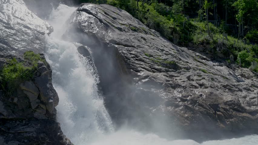 A beautiful slow motion view of a waterfall with black rocks on both sides