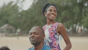 Relaxed African American Family Sitting Together on the Beach, Smiling Black Parents Enjoying Leisure Time by the Seaside During a Peaceful Vacation Day - Powered by Shutterstock - Get 15% off with code: PIKWIZARD15
