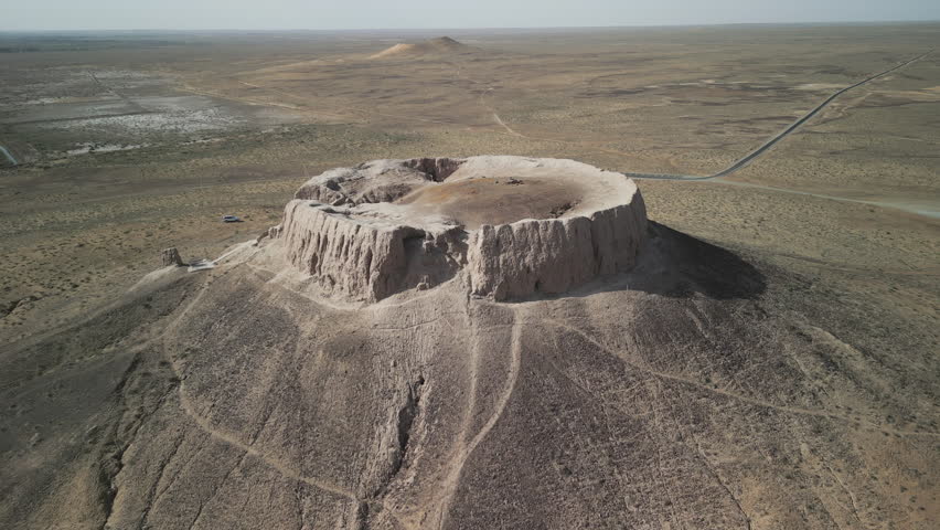 Drone view of Chilpik Dakhma rising from the desert plains. Ancient burial tower dates back to the 1st century BCE. A sacred site of Zoroastrian silence rituals