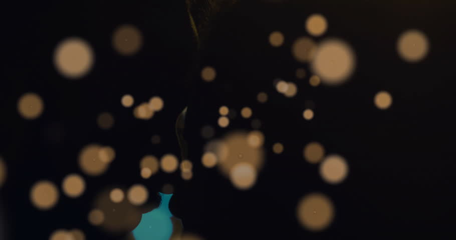 Drifting warm lights revealing couple leaning in kissing and embracing for romantic film scene. Romance, intimacy, connection, ambiance, glow, tenderness, silhouette