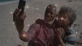Senior couple raising smartphone for selfie on beach with network overlay, reviewing gallery in app. Connection, nostalgia, technology, intimacy, relaxation, companionship, warmth - Powered by Shutterstock - Get 15% off with code: PIKWIZARD15