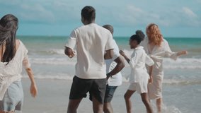 Happy Mixed-Ethnicity Young Friends Running Freely and Kicking Ocean Water on a Sandy Beach During Fun Holiday Moments - Powered by Shutterstock - Get 15% off with code: PIKWIZARD15