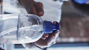 Animation of light spots over african american woman wearing face mask and disinfecting hands. Protection, virus, healthcare and lifestyle concept digitally generated video. - Powered by Shutterstock - Get 15% off with code: PIKWIZARD15