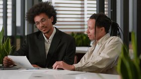 Two multiracial business men African American businessmen partners diverse colleagues males discuss financial data analyzing documents marketing project result report use laptop talk at office desk - Powered by Shutterstock - Get 15% off with code: PIKWIZARD15