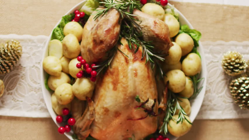 Animation of white frame and autumn leaves over thanksgiving dinner background. Thanksgiving, american tradition and celebration concept digitally generated video.
