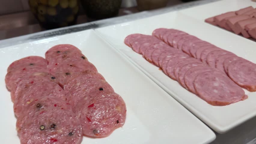 Meat plate with assortment of various tasty Spanish, french or Italian appetizers - sliced prosciutto, sausage, ham, boiled pork, balyk, jamon, sandwich, cheese, salami. Meat platter rotating