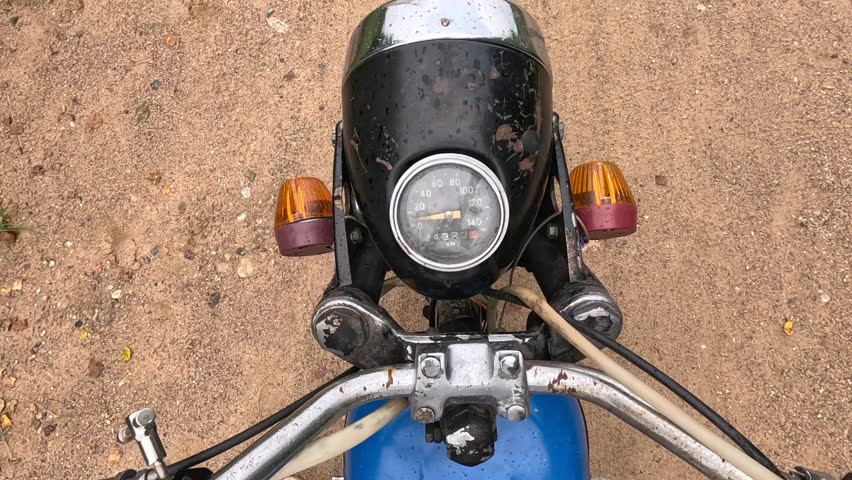 Old and rusty motorcycle speedometer showing zero speed on sand background