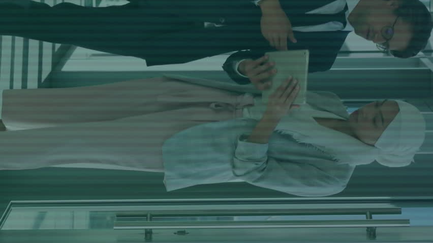 Animation of binary codes, illuminated pattern on keyboard, diverse couple discussing reports. Digital composite, multiple exposure, business, planning, teamwork and technology concept. - Powered by Shutterstock - Get 15% off with code: PIKWIZARD15