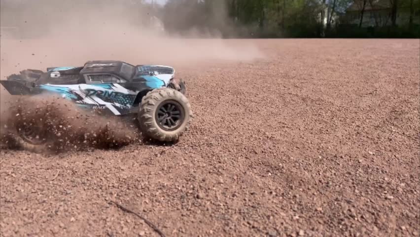 4WD RC Rally Car Remote control rally car with four-wheel drive drifting and kicking up dust on a dirt field. High-speed RC car action, wide shot with dramatic movement and realistic off-road driving.