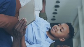 Animation of icons and 6g over happy african american father and son using tablet. Communication and spending time with technology concept digitally generated video. - Powered by Shutterstock - Get 15% off with code: PIKWIZARD15