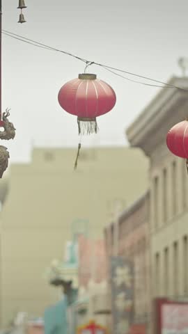 Street view of Chinatown in San Francisco, USA, featuring red lanterns, a dragon-entwined lamppost, and Chinese signage. Focus on cultural elements.