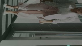 Animation of globes and connected icons over diverse coworkers discussing while walking in corridor. Digital composite, multiple exposure, communication, teamwork and globalization concept. - Powered by Shutterstock - Get 15% off with code: PIKWIZARD15