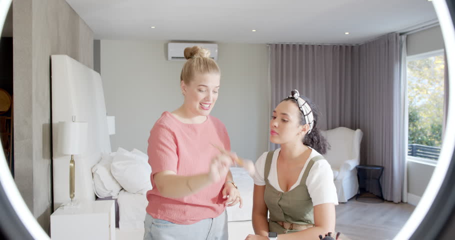 After showing puff female makeup artist dabbing, blending on model's chin in studio for contouring. Beauty, skincare, elegance, professionalism, tutorial, interior, lighting