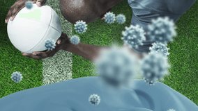 Animation of falling covid 19 cells over american football player. Global covid 19 pandemic concept, digital generated video. - Powered by Shutterstock - Get 15% off with code: PIKWIZARD15