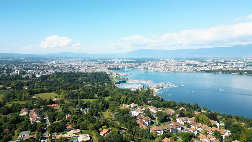 Dolly out drone shot of Rade and water fountain of Geneva during the day from Cologny, Switzerland