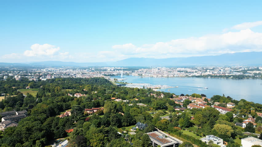 Aerial: water fountain of Geneva during the day (Rade of Geneva) from Cologny, Switzerland, push in drone shot
