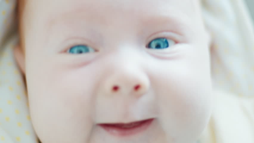 Close up portrait of the newborn boy (2 months old) with deep blue eyes in the bright white room