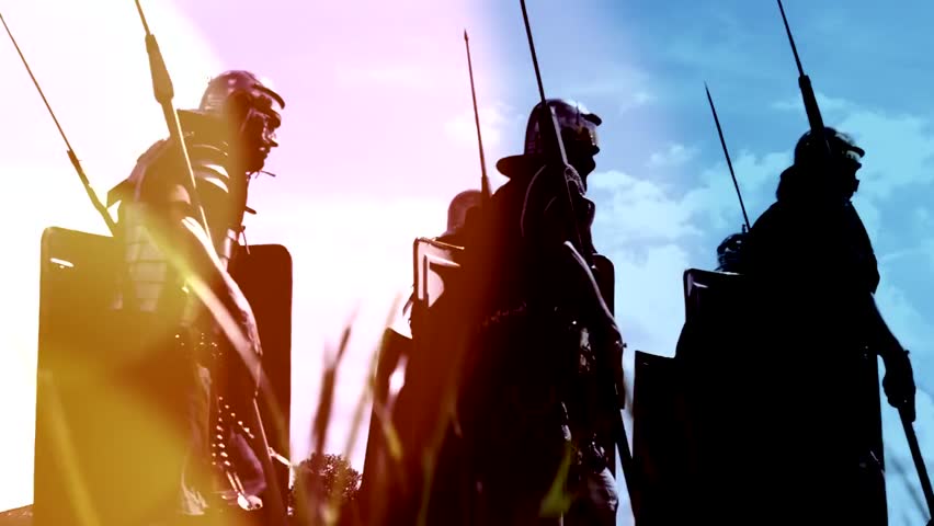 Troop of historical gladiators marching together in formation, reenacting ancient Roman warriors with dramatic cinematic visuals shot on RED Epic.
