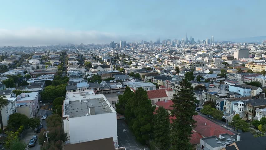 Drone flyover suburban streets, toward the downtown San Francisco skyline, daytime