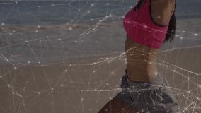 Fitness trainer activating mesh overlay on beach raising arms, rotating torso demonstrating posture. Health, wellness, vitality, fitness, technology, digital, outdoor - Powered by Shutterstock - Get 15% off with code: PIKWIZARD15