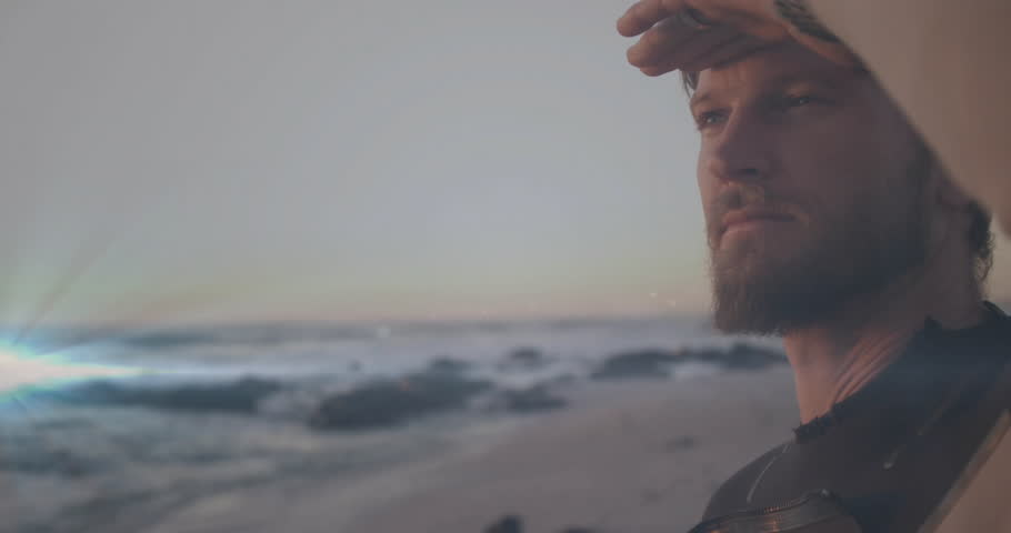 Travel marketer raising arm blocking glare on rocky shoreline, scanning sunset horizon for campaign. Voyage, adventure, exploration, serenity, silhouette, horizon, contemplation