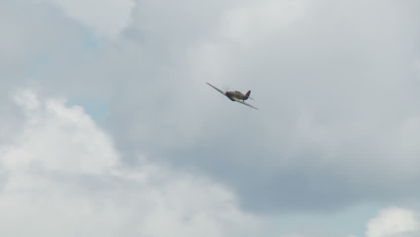 Hawker Hurricane fighter plane from World War II flying in cloudy sky.  Recorded
