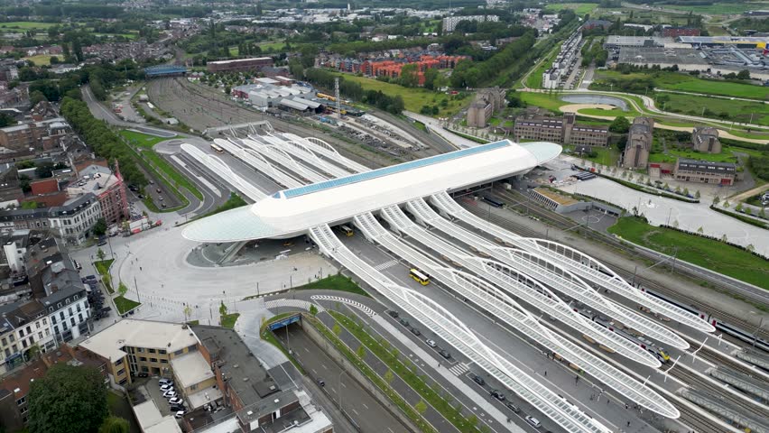 Aerial view of the modern Mons railway station amidst a blend of urban architecture and green spaces, creating a vibrant contrast, Mons, Belgium.