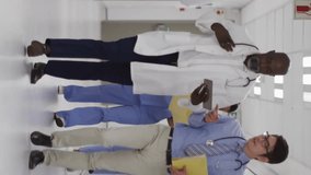 Animation of media icons over diverse doctors walking and talking in hospital. Global medicine and digital interface concept digitally generated video. - Powered by Shutterstock - Get 15% off with code: PIKWIZARD15