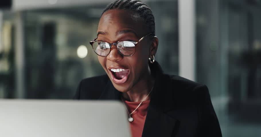 Fist pump, laptop and black woman in office at night with good news, bonus or winning prize. Applause, excited and African financial advisor with celebration for email on job promotion in workplace.