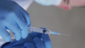 Holding syringe, doctor with mask and gloves, DNA strands animation over. Healthcare, medical, genetics, biotechnology, pandemic, safety - Powered by Shutterstock - Get 15% off with code: PIKWIZARD15