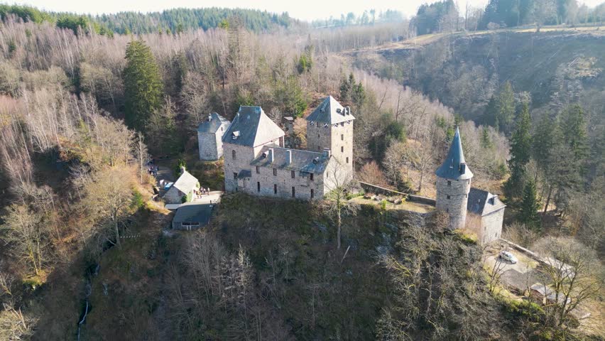 Aerial view of Reinhardstein Castle nestled among trees, a stone fortress with towers amidst the forest