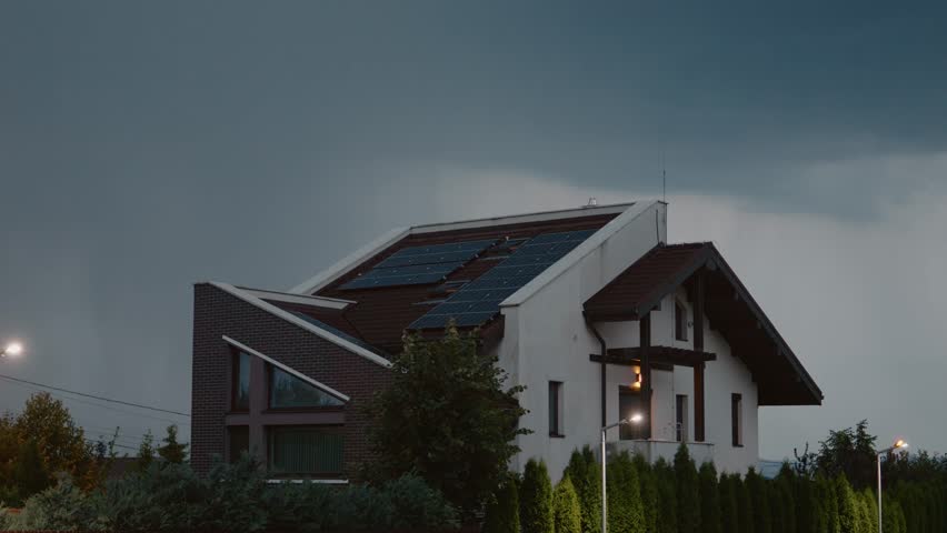 A house sits under dark clouds as rain starts to fall, accompanied by distant thunder and flashes of lightning, creating an intense and atmospheric storm.